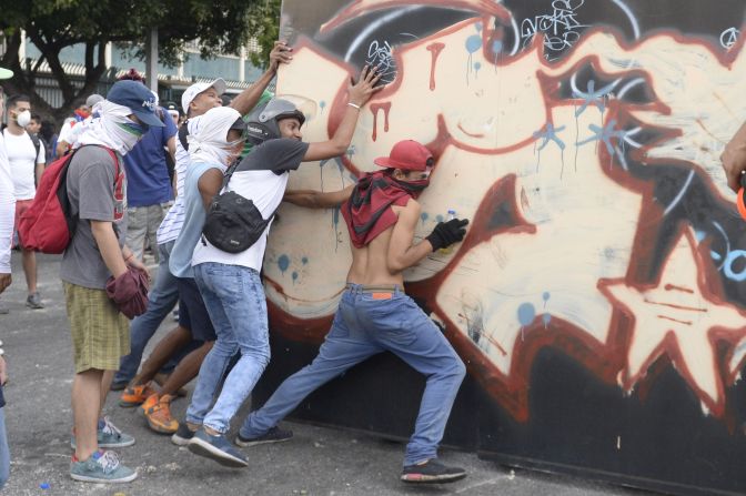 Manifestantes construyen una barricada para impedir el paso de la Guardia Nacional Bolivariana.