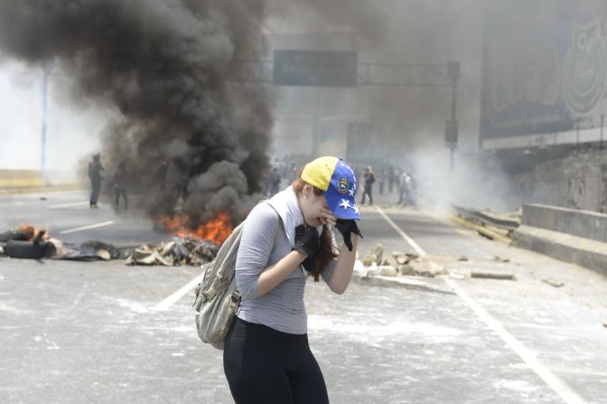 Una manifestante afectada por las bombas lacrimógenas lanzadas por la policía antimotines.