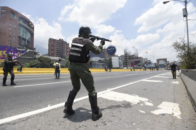 Un miembro de la Guardia Nacional Bolivariana dispara de forma horizontal una lata de gas lacrimógeno contra los manifestantes.