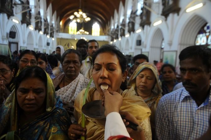 Feligreses cristianos de la India reciben la comunión durante la misa del Domingo de Ramos.