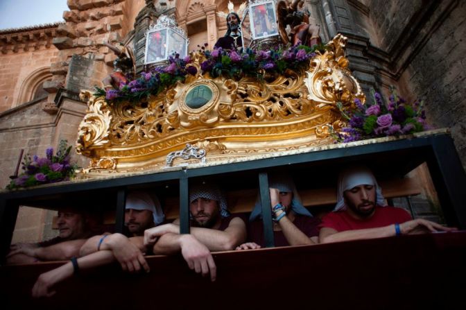 Penitentes esperan para cargar la estatua de Cristo de los Gitanos durante una procesión en Ronda, Málaga, en España.