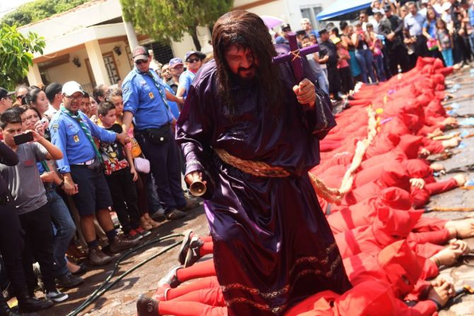 Un feligrés vestido como Jesucristo camina sobre un grupo de talciguines enmascarados en El Salvador. Los talciguines son personajes del folclor local y hacen parte de una antigua celebración que marca el comienzo de la Semana Santa.