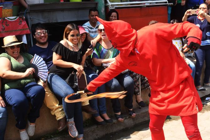 Los talciguines son juguetones, y provocan a los asistentes a la procesión en San Salvador.