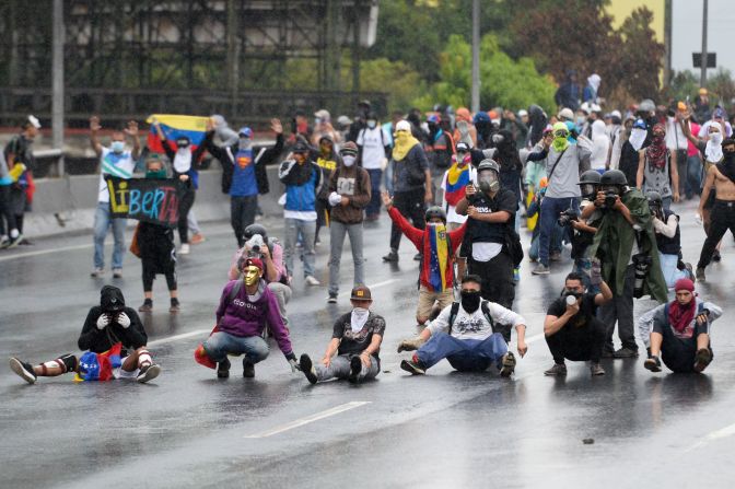 Manifestantes trancan el paso en una de las avenidas principales de Caracas. A sus espalda, la prensa.