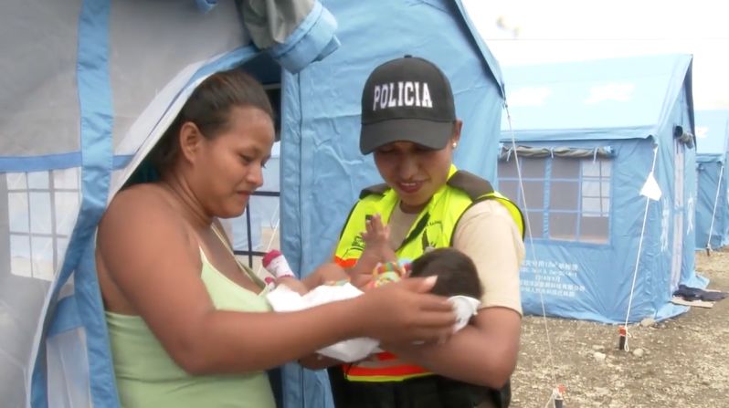 Yajaira le muestra su hija a una policía en el albergue Divino Niño.