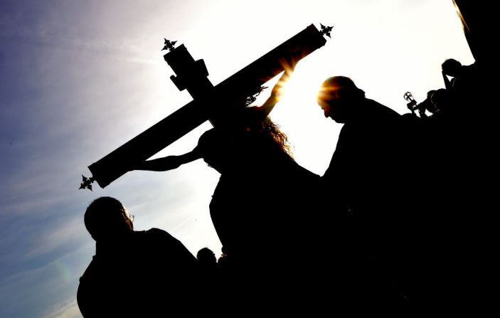 Integrantes de la hermandad Cristo Salvador se reúnen alrededor de una efigie de Jesucristo durante una procesión de la Semana Santa el 14 de abril de 2017 en la playa de Valencia, España.