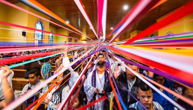 Católicos en el pueblo de Cot, Cartago, sostienen cintas de colores atadas a la estatua de Jesús de Nazaret, mientras asisten a una misa masiva en la iglesia de San Antonio de Padua, antes de una procesión conocida como “Jesús Nazareno de las cintas”, durante la celebración de la Semana Mayor.