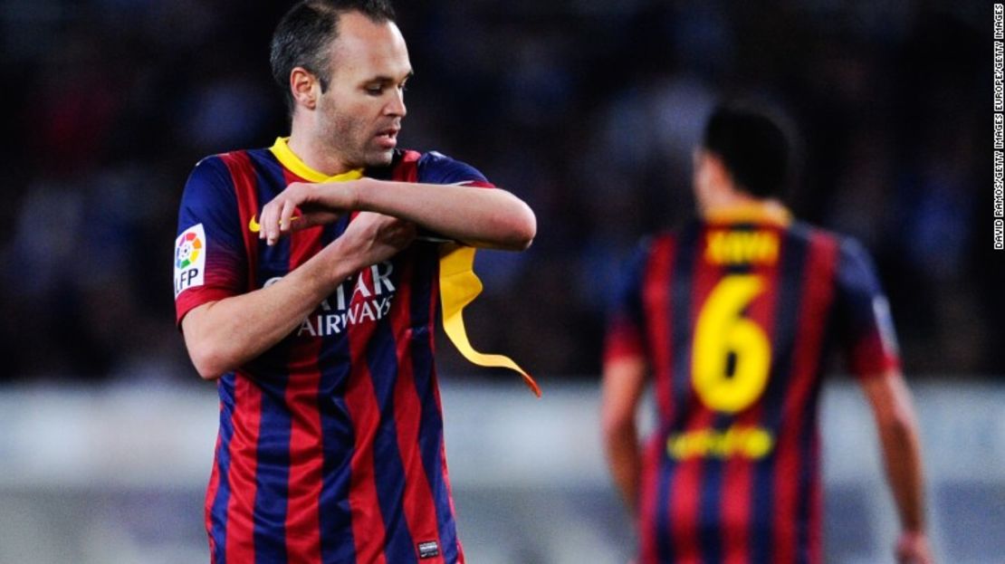 Andrés Iniesta recibe de Xavi Hernández el brazalete del capitán del Barcelona.