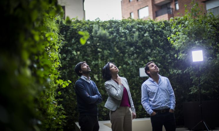 Nicolás Borda y Pablo Atuesta, cofundadores de Groncol, le explican a Gabriela Frías la tecnología utilizada para cubrir de verde un edificio.