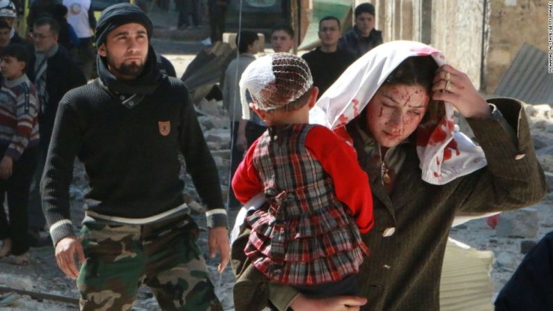 Una mujer con sangre en su rostro lleva en brazos a una niña herida tras un ataque aéreo el 15 de marzo de 2014 en Aleppo. (MOHAMMED AL-TAYBMOHAMAD AL-TAYB/AFP/Getty Images