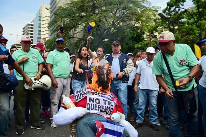 Oposición y oficialismo marchan este 19 de abril en Venezuela. Aquí, un grupo de manifestantes de la oposición queman una representación del presidente Nicolás Maduro en Caracas.