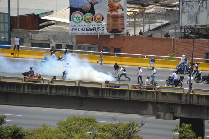 Manifestantes devuelven un gas lacrimógeno lanzado por las fuerzas antimotines.