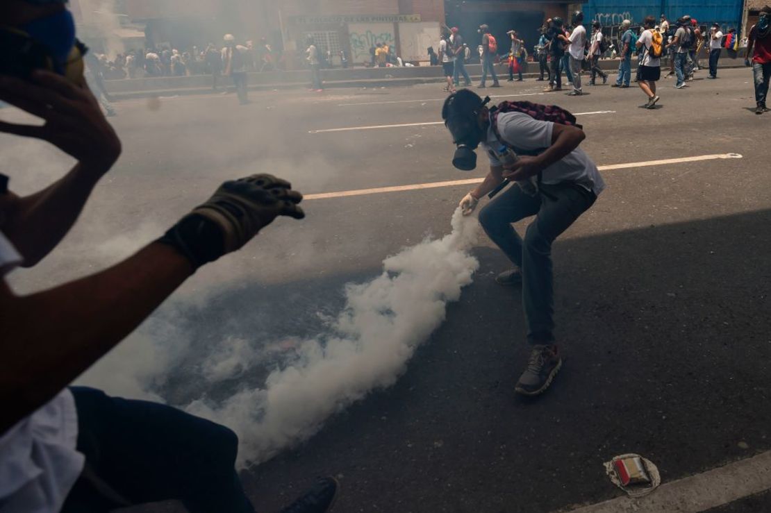 Un manifestante arroja una alta de gas lacrimógeno durante las protestas de este miércoles en Venezuela.