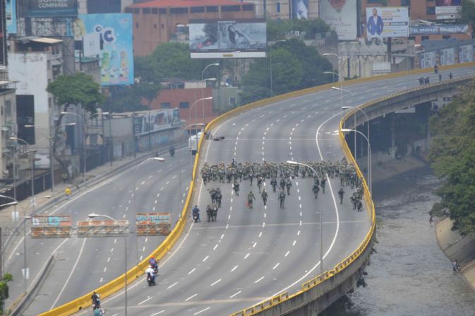 La policía de Venezuela se posa en el puente vehicular de la avenida Francisco Fajardo de Caracas por donde pasa la marcha de la oposición.