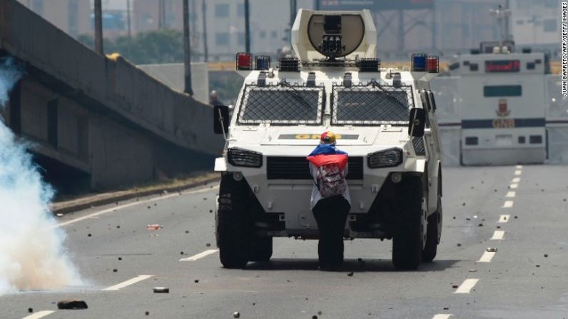 Una manifestante se para frente a un vehículo armado de la policía antidisturbios de Venezuela durante la protesta del 19 de abril en Caracas.