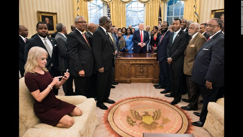 La asesora de la Casa Blanca Kellyanne Conway toma una foto de Trump junto a los líderes de universidades históricamente negras en la Oficina Oval, el lunes 27 de febrero. La imagen de ella arrodillada en el sofá generó bastantes memes en las redes sociales.