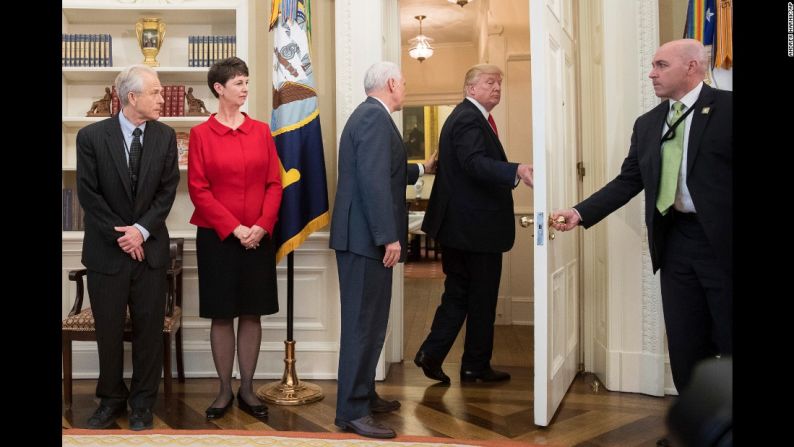 El vicepresidente Mike Pence, tercero de izquierda a derecha, intenta detener a Trump mientras éste se retira de una ceremonia de firma de decretos, el viernes 31 de marzo. Durante el acto oficial, los periodistas de la Casa Blanca le preguntaron al presidente sobre su exasesor de seguridad nacional Michael Flynn, quien se ofreció a testificar en la investigación que se adelanta por la supuesta participación de Rusia en las elecciones estadounidenses de 2016. Trump ignoró las preguntas y se dirigió a otra sala para firmar dos decretos relacionados con la política comercial.