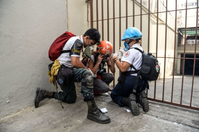 Un manifestante severamente afectado por el gas lacrimógeno se refugia en un rincón mientras continúan las marchas y los disturbios en Caracas.