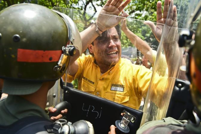 El diputado de la oposición Carlos Paparoni empuja los escudos de las autoridades venezolanas durante la protesta.