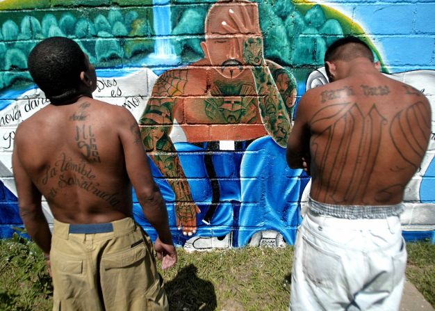 Dos miembros de la Mara Salvatrucha muestran sus tatuajes en una unidad de la Penitenciaria Nacional en Tamara, a 30 kilómetros de Tegucigalpa (Honduras) en el 2006. Las enormes iniciales tatuadas en estilos góticos son un símbolo de ambas maras.