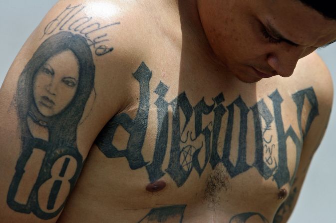 Foto de septiembre del 2016 en la que se observa a un miembro de la Mara 18 tras ser detenido en El Salvador. Regularmente tienden a tatuarse a sus novias, quienes también, en la mayoría de las ocasiones, son mareras.