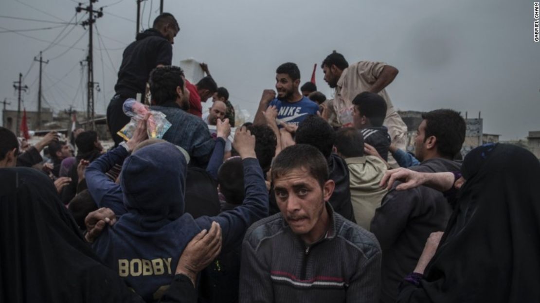 Los residentes de Yarmouk, al oeste de Mosul, rodean un camión de distribución de alimentos el 11 de abril.