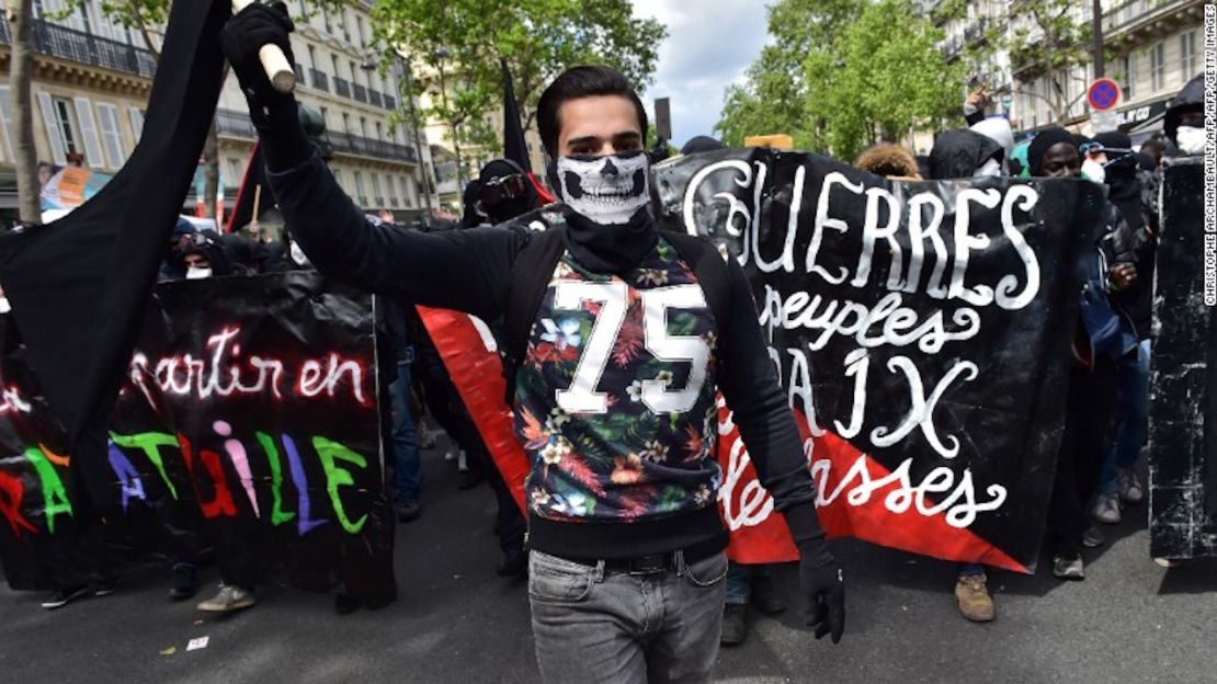 Un hombre sostiene una bandera liderando las marchas anuales del Día de los Trabajadores en París el Primero de mayo de 2017.