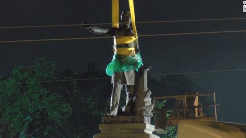 Cerca de las 4 de la mañana, dos trabajadores se acercaron a la estatua en un ascensor de trabajo y envolvieron parte de ella en plástico verde. Los trabajadores ataron el torso del monumento con cintas amarilla y aseguraron el cráneo de la estatua. Un trabajador quitó la base de la estatua de la columna usando una herramienta larga y plana.