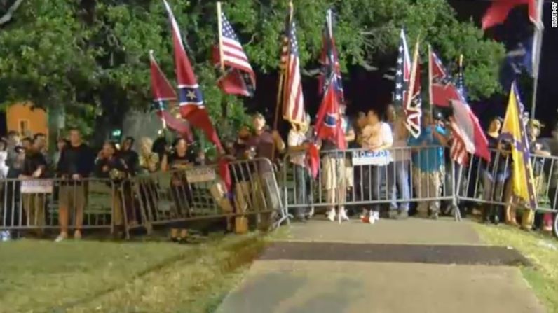 Partidarios del monumento de Davis ondearon banderas de la Confederación y de Estados Unidos este jueves en la mañana antes de que la estatua fuera retirada.