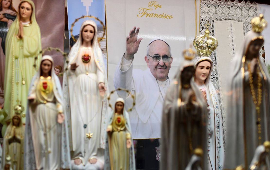 Aspecto de un afiche del papa Francisco entre imágenes de la Virgen María en Fátima.