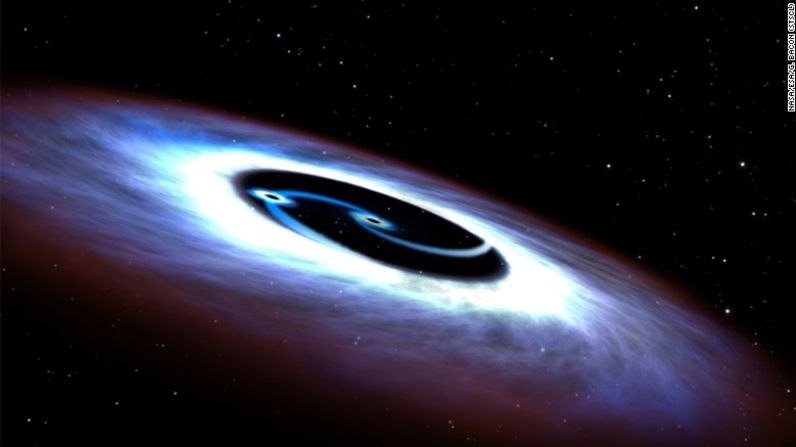 Una ilustración artística muestra un agujero negro binario encontrado en el quasar en el centro de la galaxia Markarian 231. Los astrónomos que usaron el telescopio espacial Hubble de la NASA descubrieron que la galaxia estaba alimentada por dos agujeros negros que "giraban furiosamente unos sobre otros", dijo la agencia espacial en un comunicado de prensa.