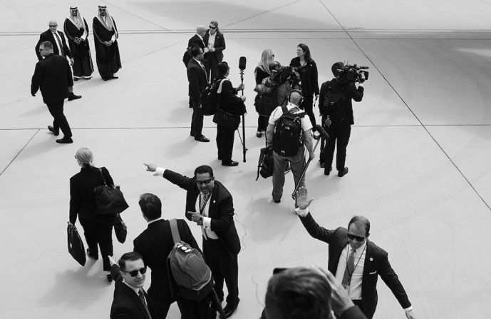 Personal de seguridad y prensa se reúne en la pista después del aterrizaje del Air Force One en Riad.