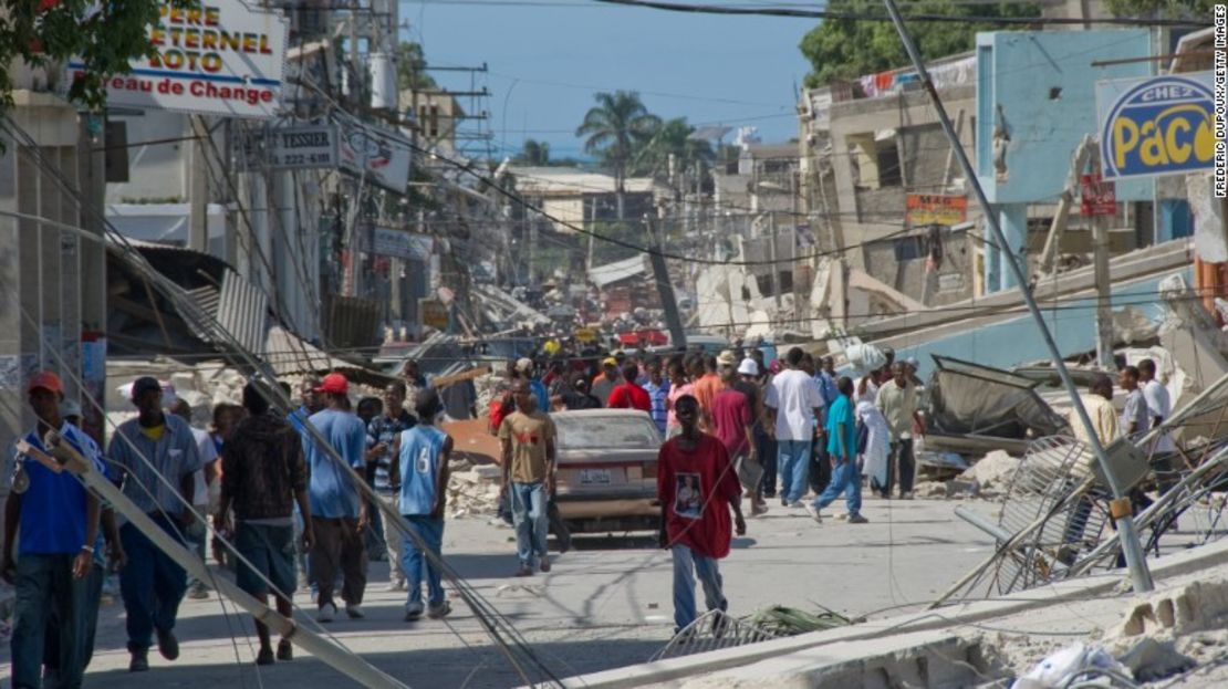 Haitianos deambulan por las calles de Puerto Príncipe, junto a un internado que resultó destruido por el terremoto, en enero del 2010.