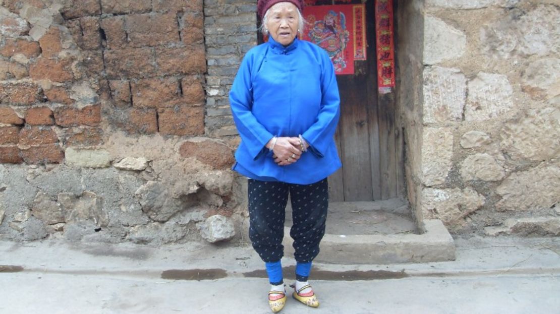 Una mujer con zapatos amarillos bordados en Yunnan, China.