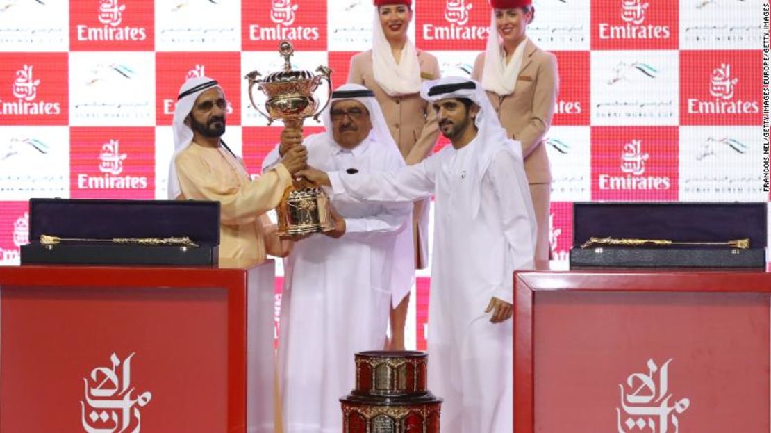 Sheikh Mohammed (I) recibe el trofeo después de la victoria de su caballo Thunder Snow en la Copa Mundial de Dubai.