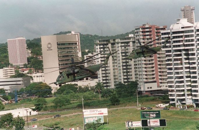 En 1989 Noriega fue acusado en Estados Unidos por cargos de lavado de dinero y narcotráfico. En medio de crecientes disturbios en Panamá, el entonces presidente estadounidense George H.W. Bush ordenó la invasión de Panamá en diciembre de 1989. En la imagen, helicópteros estadounidenses en Ciudad de Panamá.