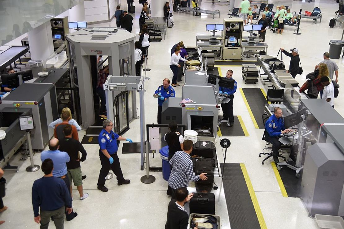 Oficiales inspeccionan a pasajeros antes de que tomen sus vuelos en el aeropuerto de San Luis (Misuri).