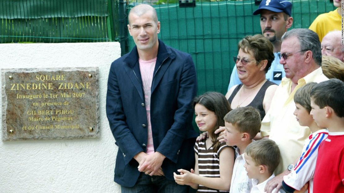 Zinedine Zidane (i) posa junto a los antiguos anfitriones Jean-Claude (d, segunda fila) y Nicole Elineau (Segunda desde la derecha, segunda fila) durante una ceremonia de nombramiento de una plaza en Pegomas (Francia) en mayo del 2007. La pareja recibió a Zidane mientras era un jugador juvenil en el Cannes en 1987.