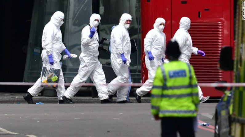 Un grupo de forenses de la policía camina en la calle cerca al mercado de Borough.