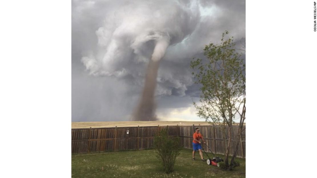 Cecilia Wessels tomó esta increíble foto de su esposo Theunis mientras podaba el pasto, con un enorme tornado detrás.