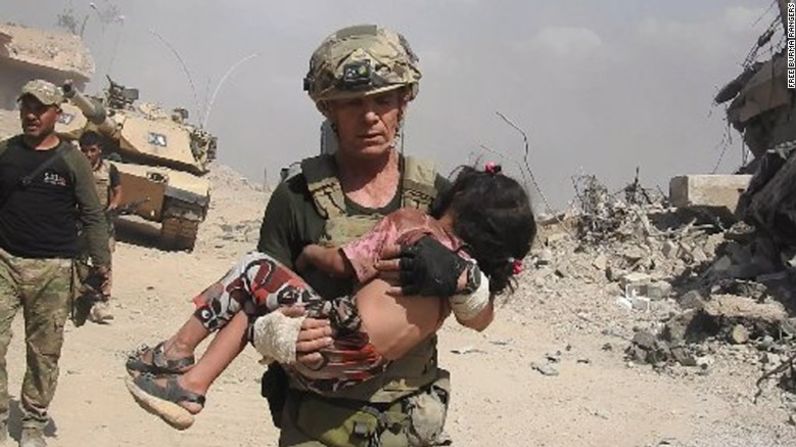 Dave Eubank, de la organización de voluntarios "Free Burma Rangers”, lleva a una niña a un lugar seguro después de encontrarla escondida bajo el hiyab de su madre muerta. Estuvo allí durante dos días. La niña fue rescatada en el oeste de Mosul, mientras había fuego abierto en la zona. Foto cortesía de Free Burma Rangers.