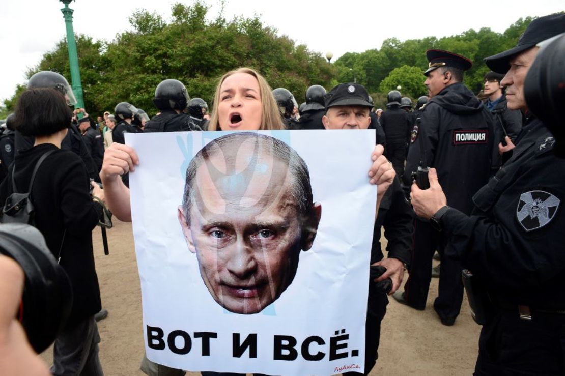 Una mujer sostiene un cartel en el que se muestra el retrato del presidente ruso Vladimir Putin con la leyenda "eso es todo" durante una manifestación no autorizada de la oposición en el centro de San Petersburgo este 12 de junio.