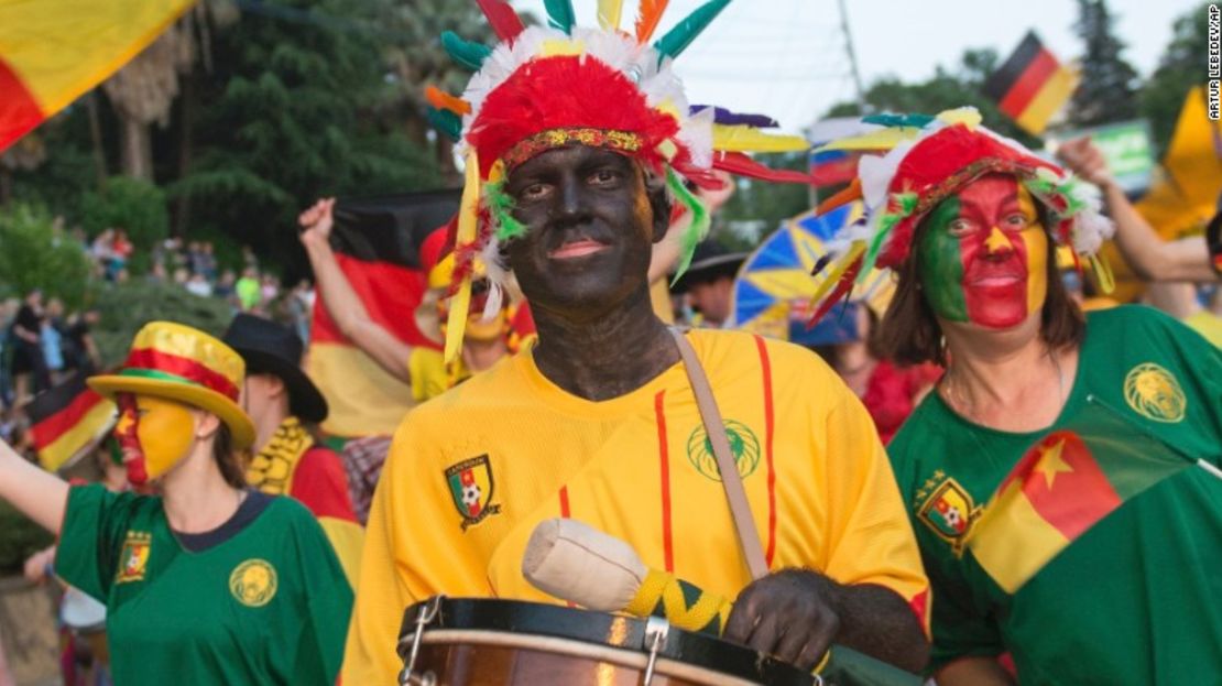 Gente con la cara pintada de negro y portando bananos participan en un desfile en Sochi.