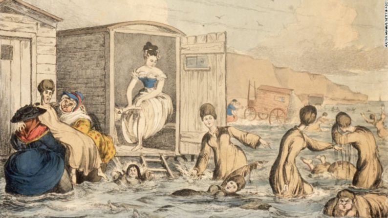 En 1825, las mujeres usaban "vestidos de baño" en la playa. Esta ilustración muestra a las señoras de la época aventurarse en el océano a través de las máquinas de baño –una especie de vestuario sobre ruedas– que las llevaba directamente al agua.