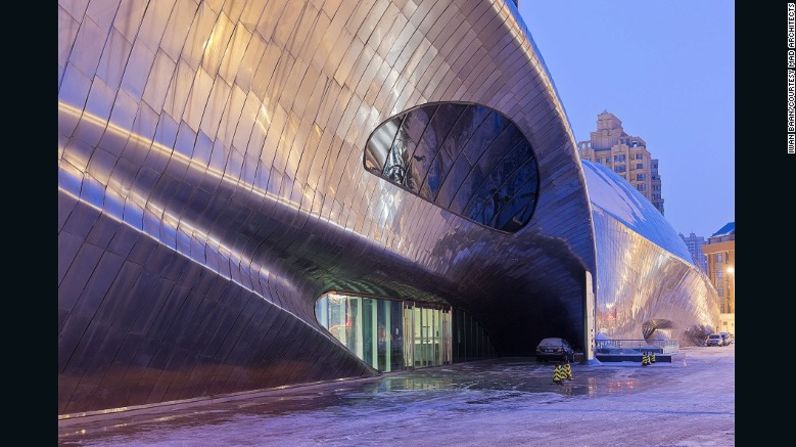 Museo de Escultura de Madera de China (2013), Harbin, China – Las placas de metal pulido en el espejo exterior reflejan las luces de la ciudad por la noche.