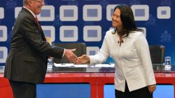 Peruvian presidential candidate for the Fuerza Popular (Popular Strength) party Keiko Fujimori (R) shakes hands with Peruvian presidential candidate Pedro Pablo Kuczynski of the "Peruanos por el Kambio" (Peruvians for change) party before a televised debate in Lima on May 29, 2016.  
Fujimori and Kuczynski will compete in Peru's June 5 runoff election. / AFP / CRIS BOURONCLE