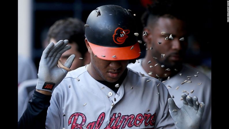 Semillas de girasol vuelan en el dugout mientras Jonathan Schoop celebra un jonrón con sus compañeros de Baltimore el martes 4 de julio.