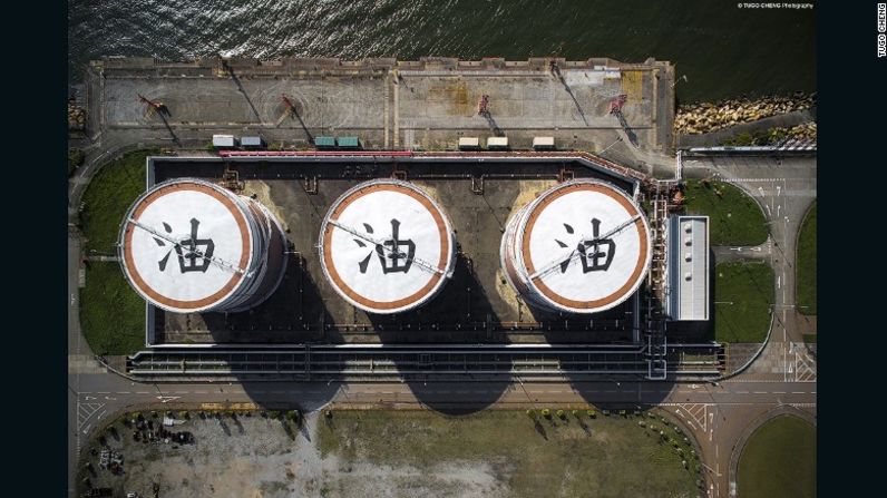 En el noroeste de Hong Kong, los tanques de almacenamiento de petróleo en centrales eléctricas están pintados en el techo con enormes caracteres chinos que representan la palabra petróleo. Palabra que le da título a esta fotografía de la serie.