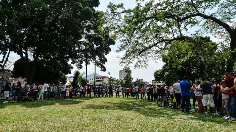 Venezolanos hacen fila en Cali, Colombia, para participar en la consulta popular convocada por la oposición.