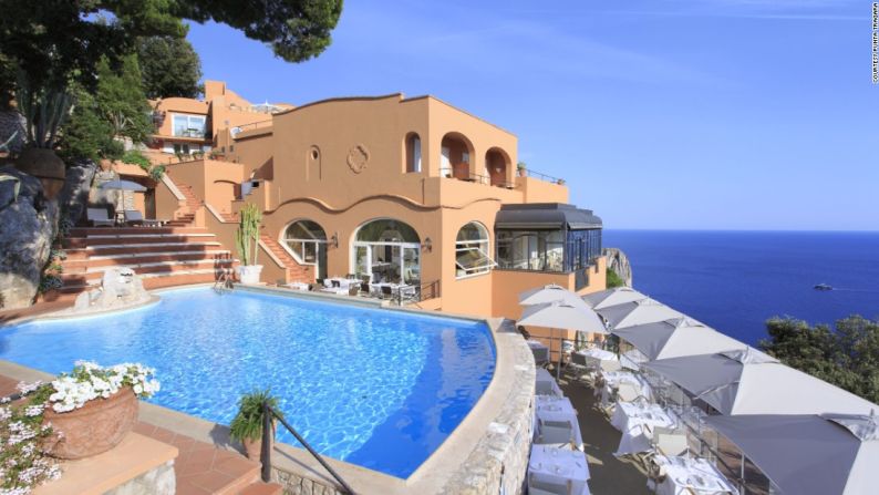 El famoso Hotel Punta Tragara, en la isla de Capri (Italia), tiene una piscina con increíbles vistas hacia las icónicas rocas Faraglioni, rodeada de un montón de cipreses. El hotel a hospedado a ricos y famosos durante casi un siglo.